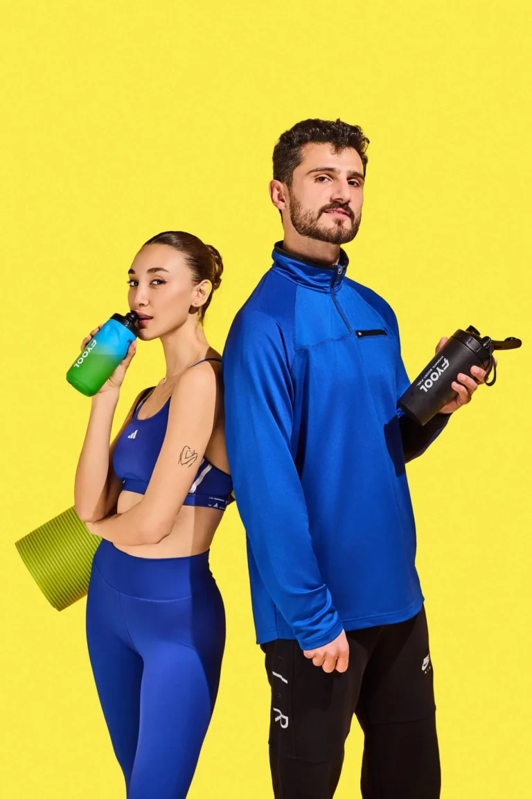 Man and woman in workout attire holding Fyool hydration
