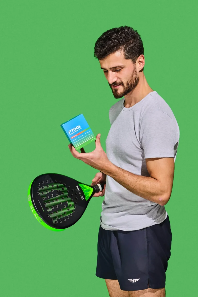 Man holding Fyool hydration drink pack with a paddle racket